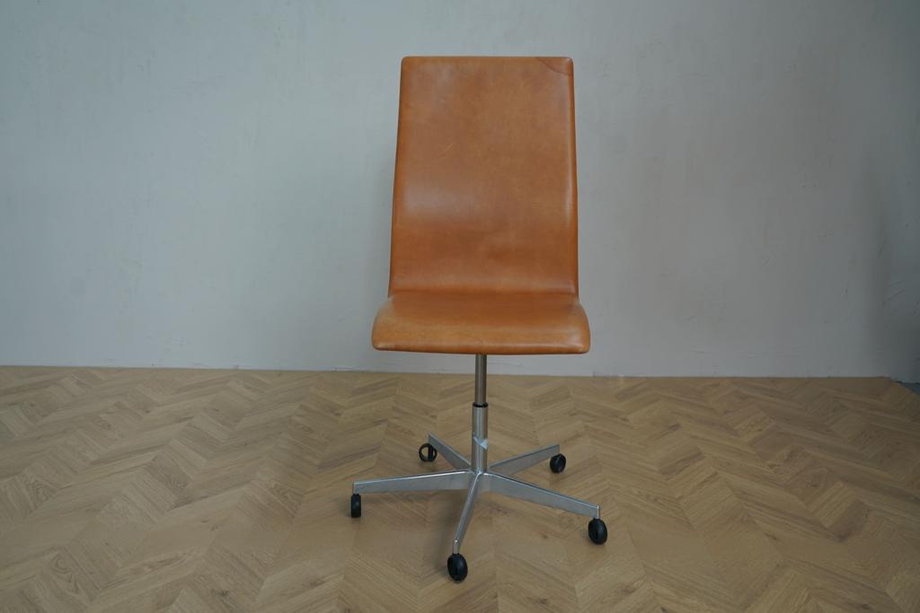 Oxford kontorstol i cognacfarvet læder med hjul, set forfra – designet af Arne Jacobsen for Fritz Hansen